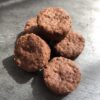 cinq petits biscuits ronds au chocolat déposés sur une ardoise