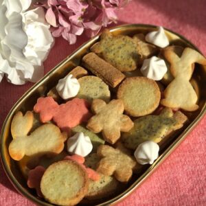 Plat de biscuits en forme de lapin fleur mouton beiges et roses sur fond rse avec fleurs decoratives